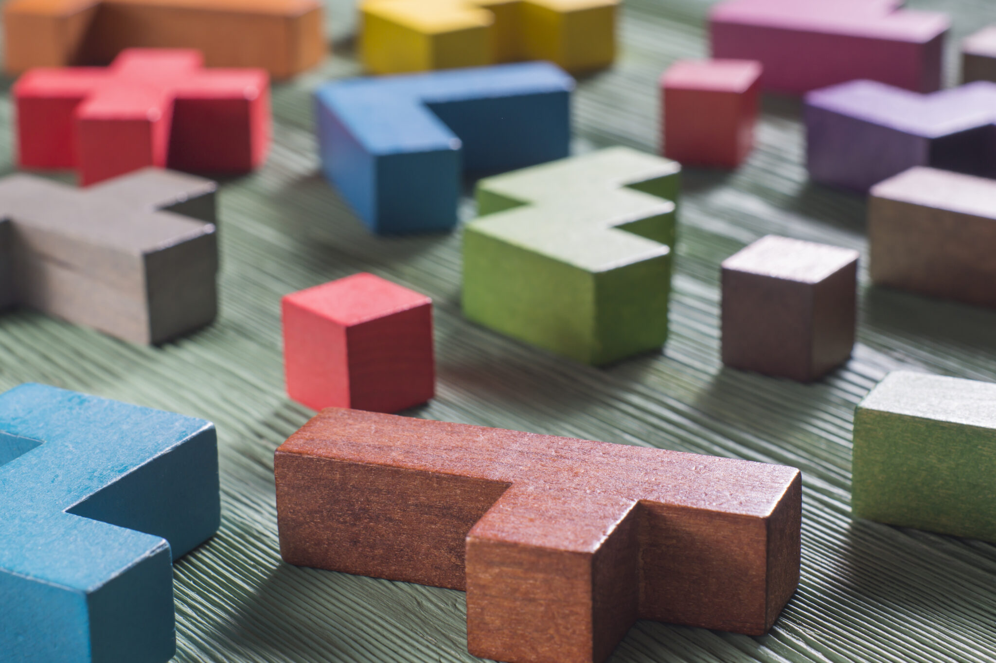 Abstract construction from wooden blocks tetris shapes. The concept of logical thinking, geometric shapes. Colorful wooden building blocks.The concept of logical thinking. Geometric shapes on a wooden background. Tetris toy wooden blocks.